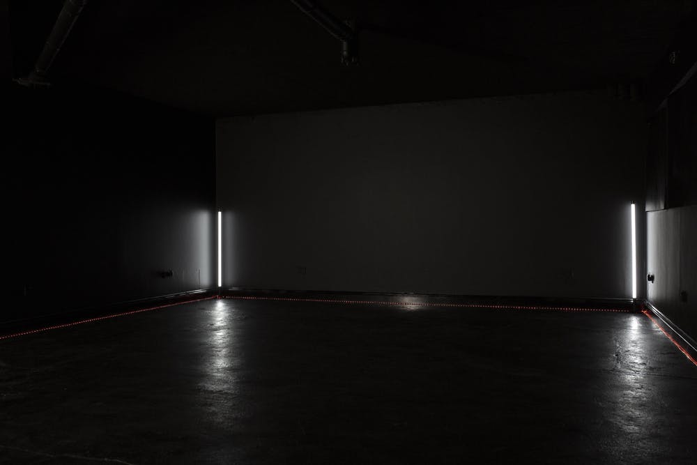 Minimalist event space in Blackout studio with dim lighting for intimate gatherings.