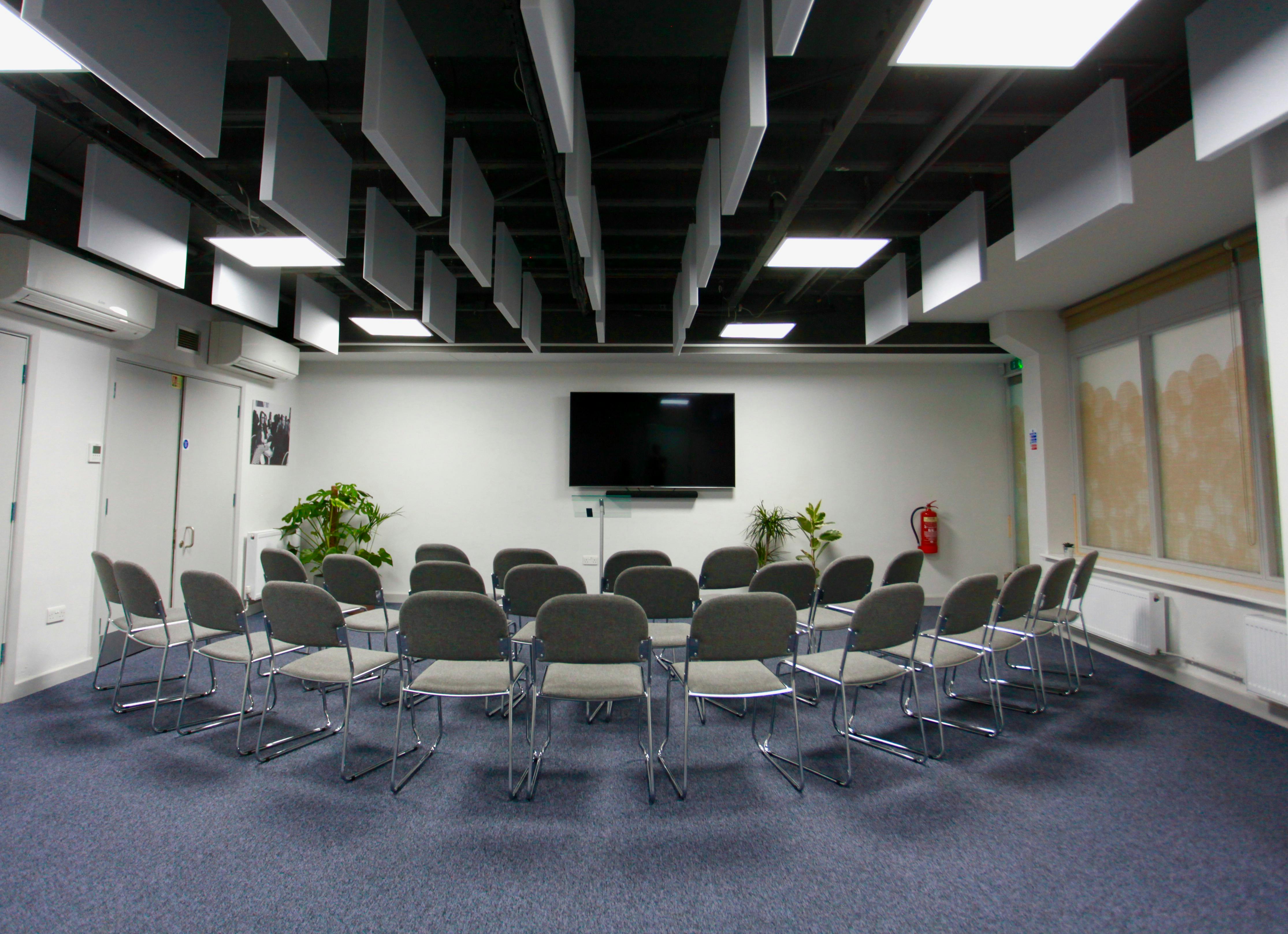 Meeting room with chairs and screen at Neal Street Espresso for workshops and presentations.