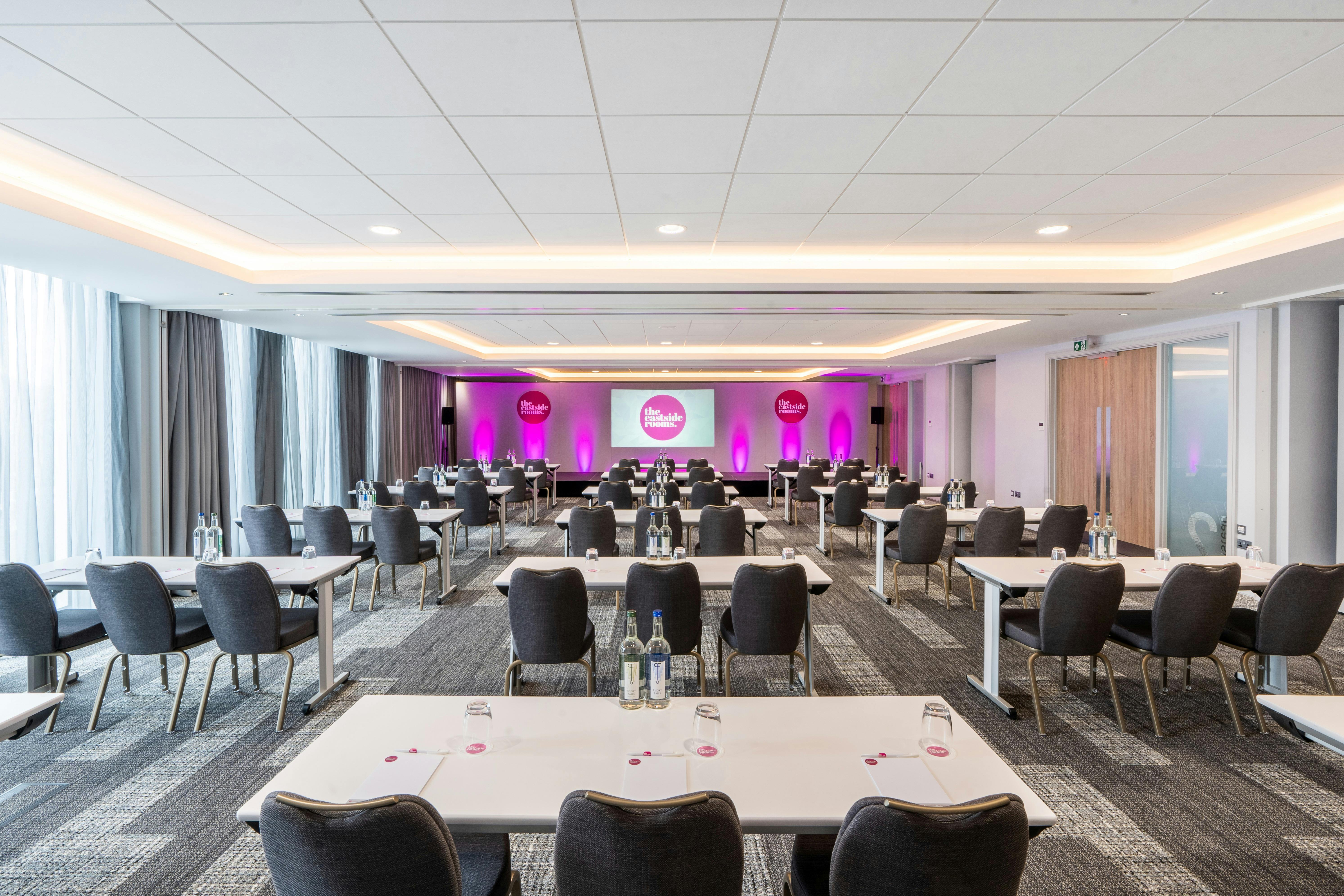 Modern conference room with pink accents, ideal for meetings and networking events.