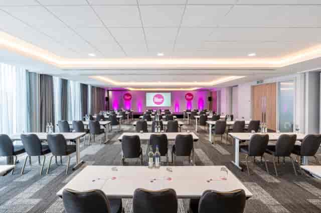 Modern conference room with pink accents, ideal for meetings and networking events.