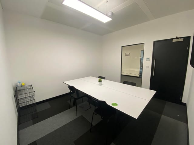 Minimalist meeting room at SPS2, featuring a white table and natural light for brainstorming.
