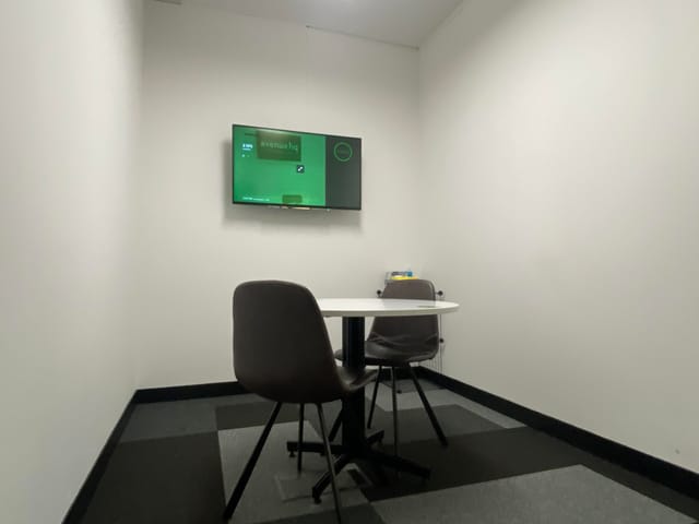 Modern meeting room at SPS3, featuring a wall-mounted screen for focused discussions.