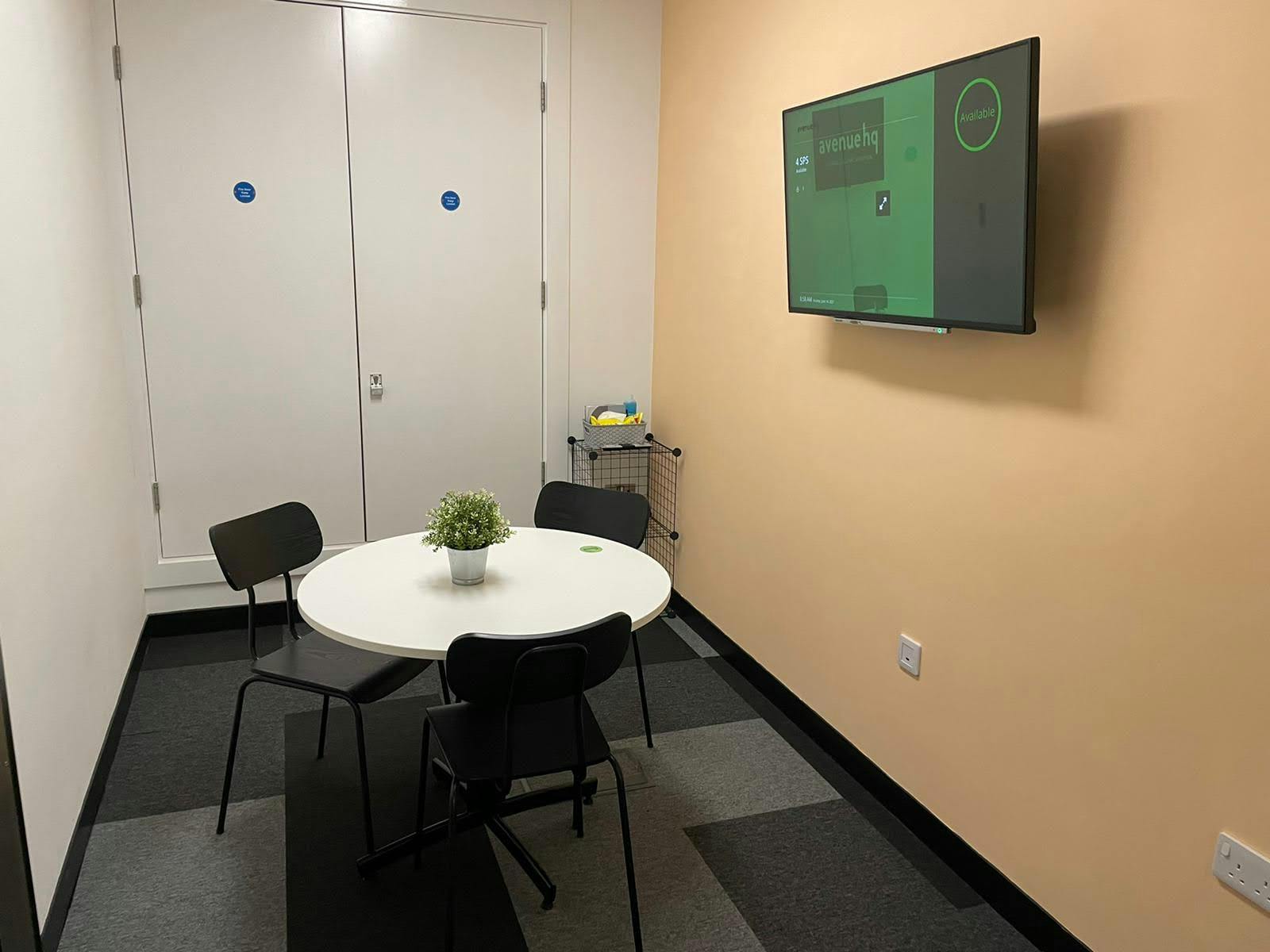 Small meeting room with round table, ideal for brainstorming sessions at Avenue HQ.