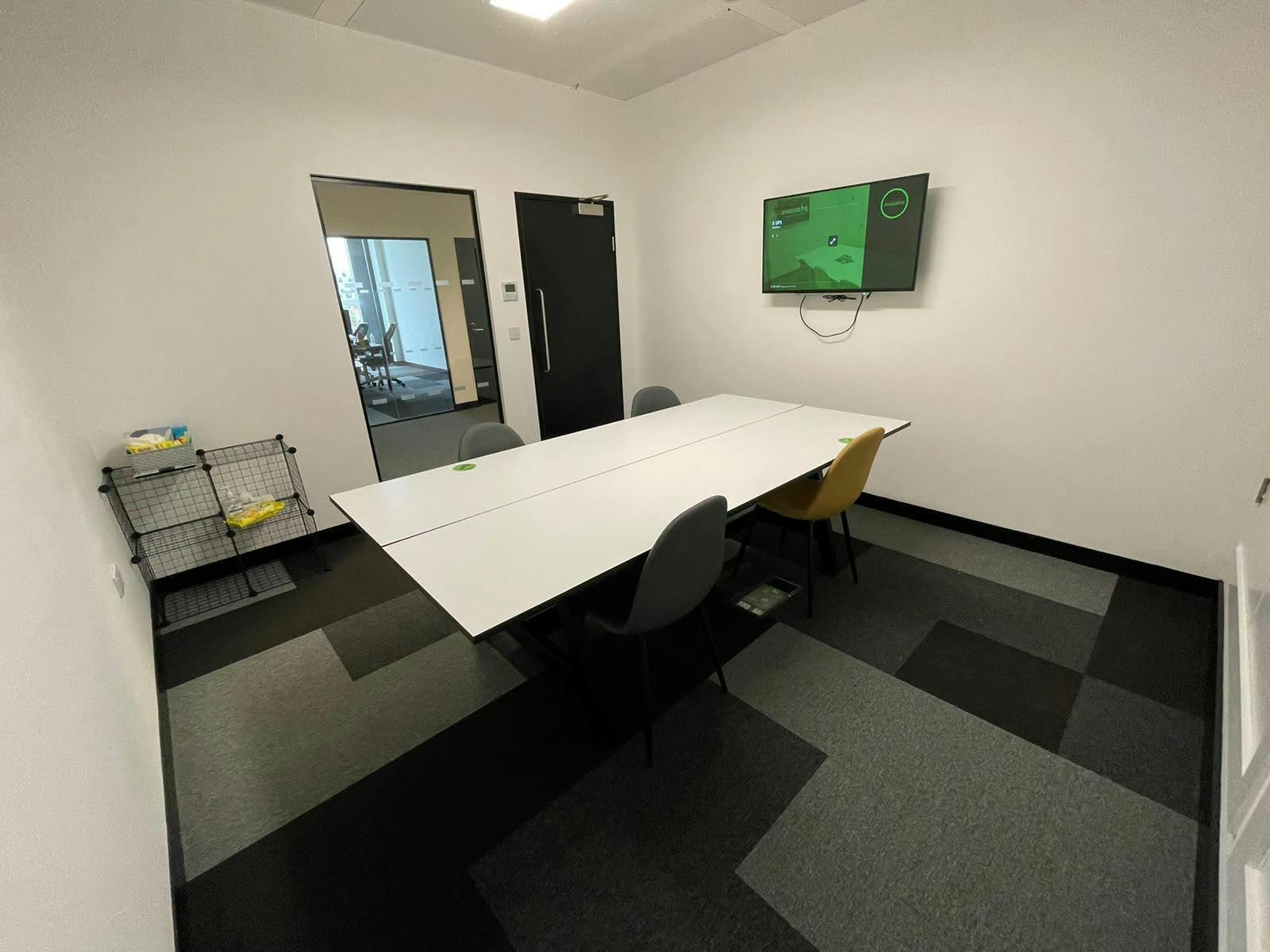 Modern meeting room at SPS5, featuring a sleek white table and ergonomic chairs.