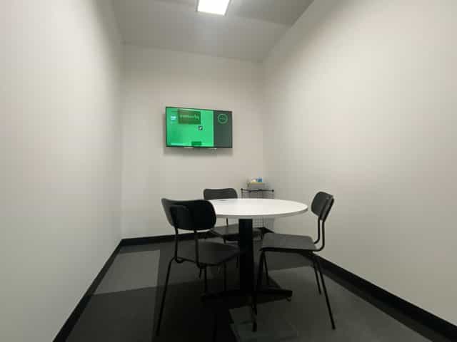 Minimalist meeting room with round table, ideal for brainstorming sessions at Avenue HQ.