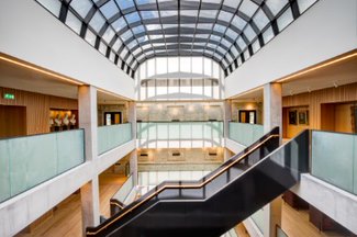 Modern atrium with glass ceiling, perfect for meetings and corporate events. - Banner