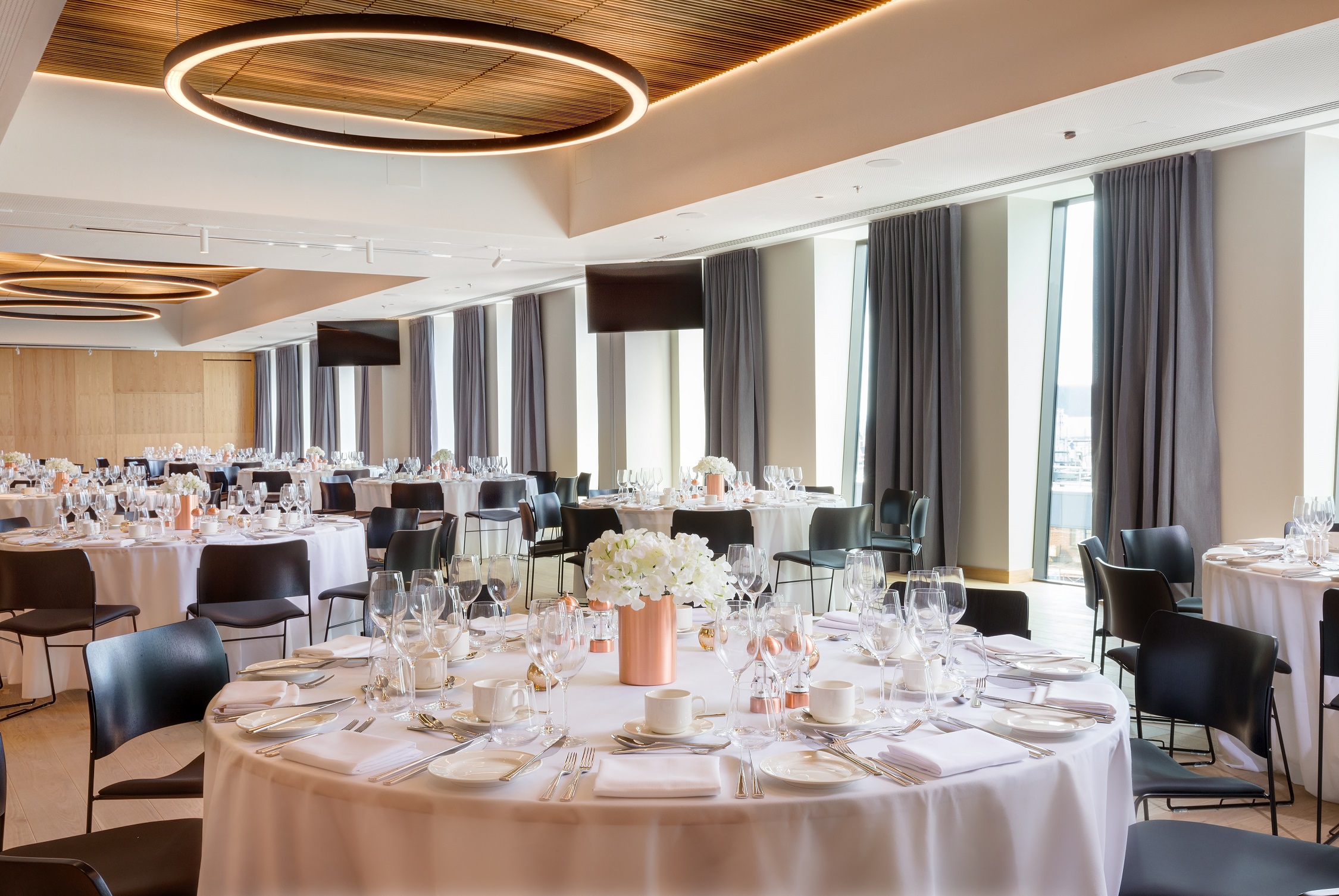 Elegant event space with round tables, perfect for weddings and corporate gatherings. - Banner