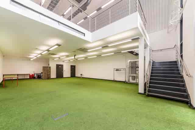 Versatile event space with artificial turf at Arch 29, perfect for workshops and gatherings.