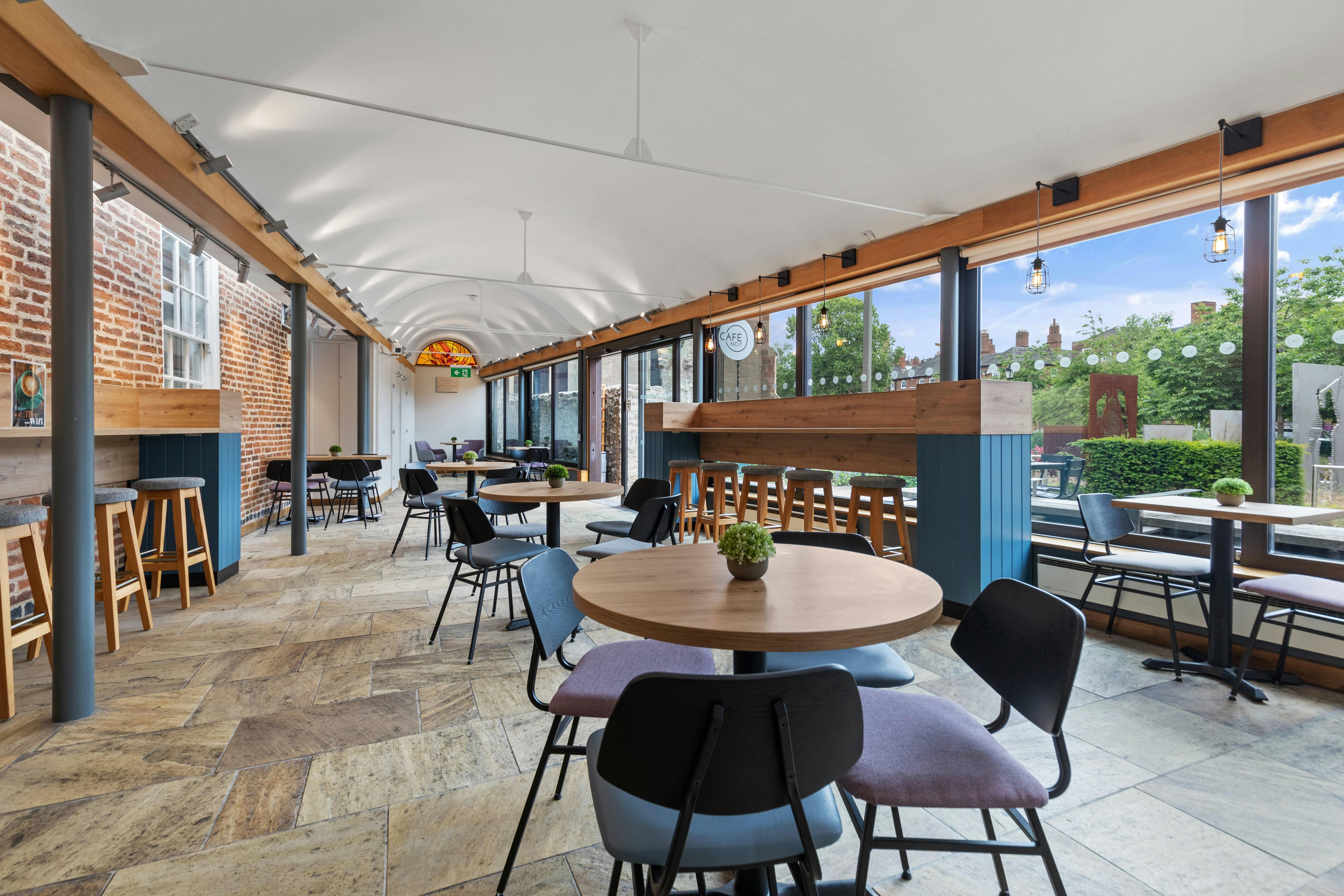 Modern event space at Cafe No:7 with large windows, perfect for networking and meetings.