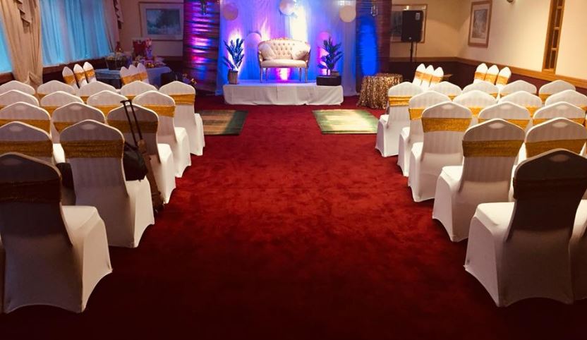 Wansbeck Suite at Britannia Hotel: elegant event space with white chairs and gold sashes. - Banner