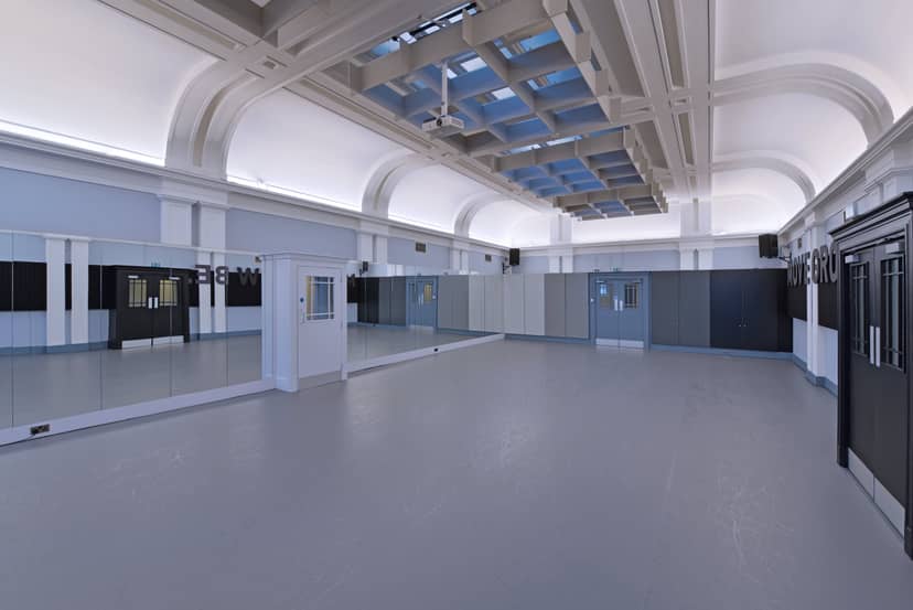 Spacious event venue with high ceilings and mirrors, perfect for workshops and fitness classes.