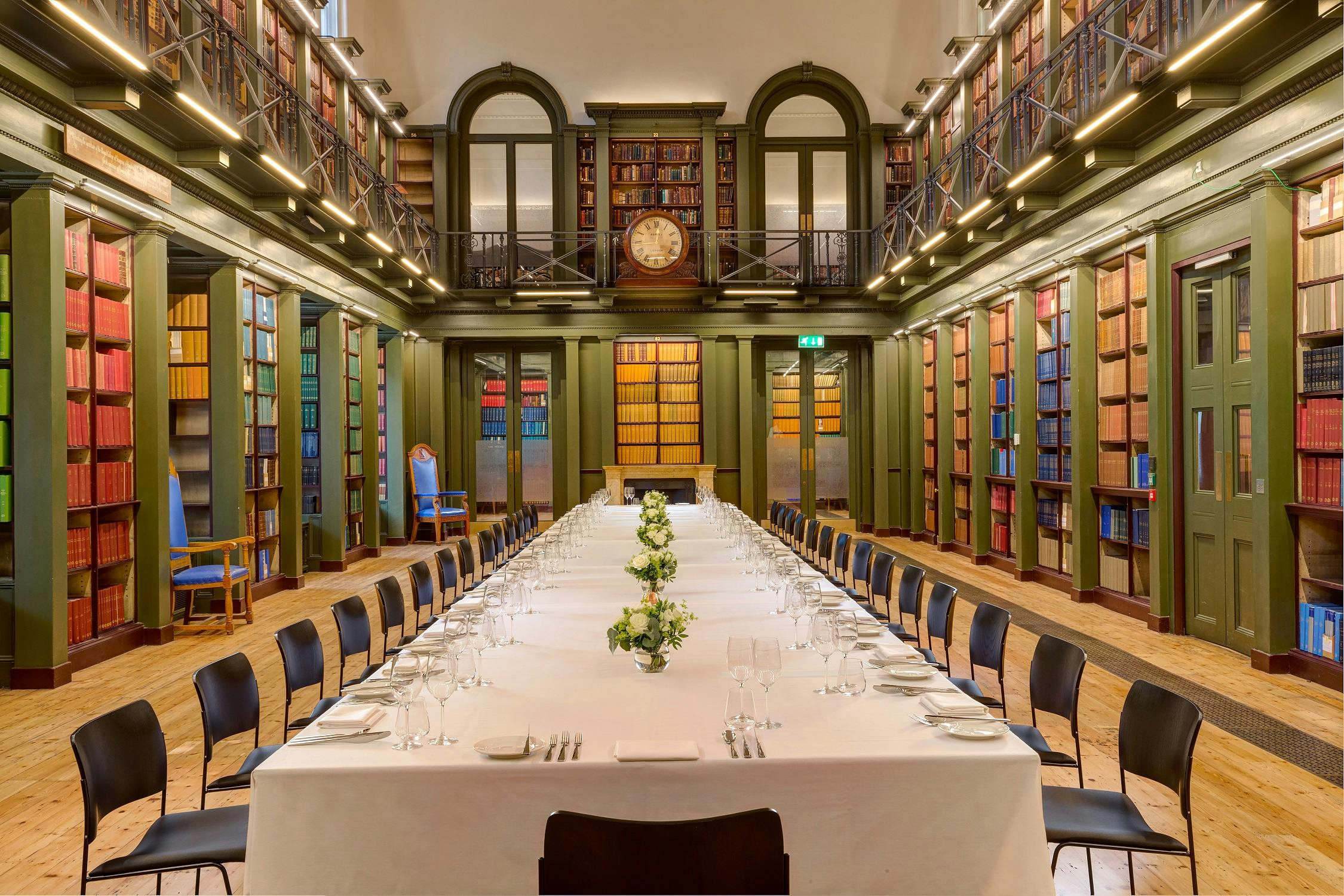 Elegant meeting space with long table and bookshelves, ideal for corporate events.