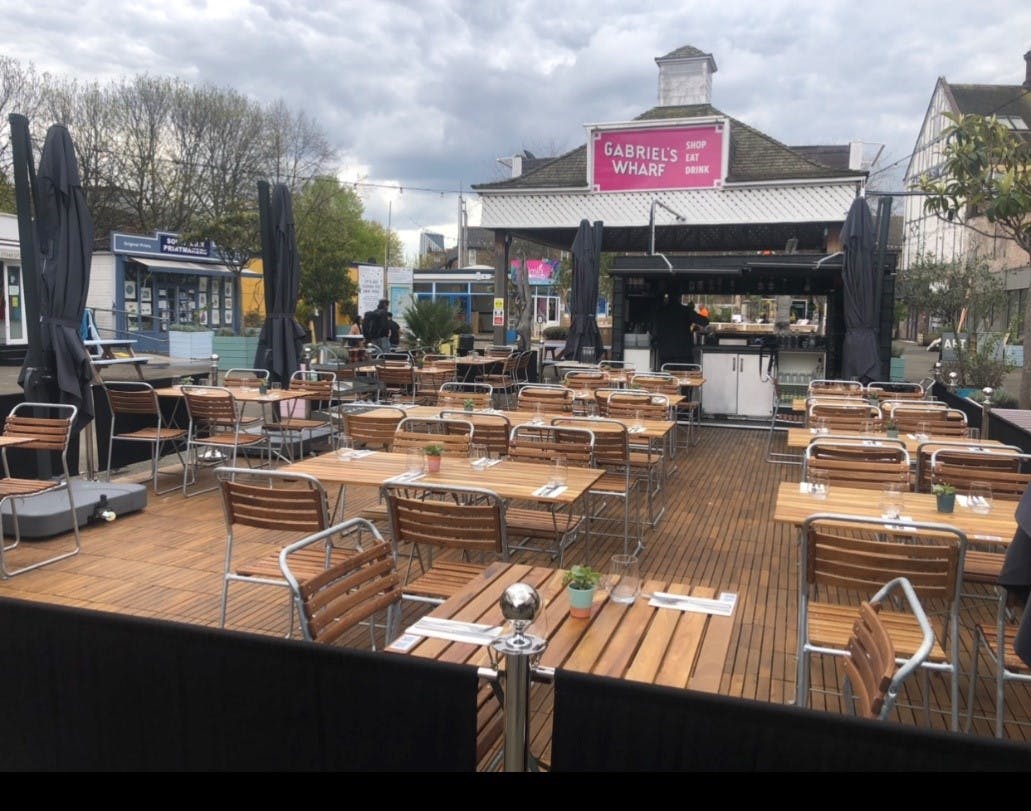 Outdoor event space in Paradiso London with wooden tables, ideal for gatherings and networking.