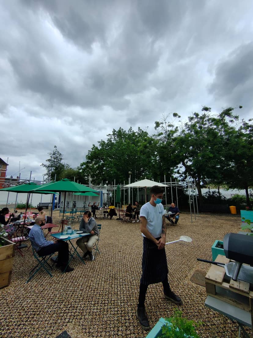 Outdoor event space at Ebury with green umbrellas, perfect for networking and casual meetings.