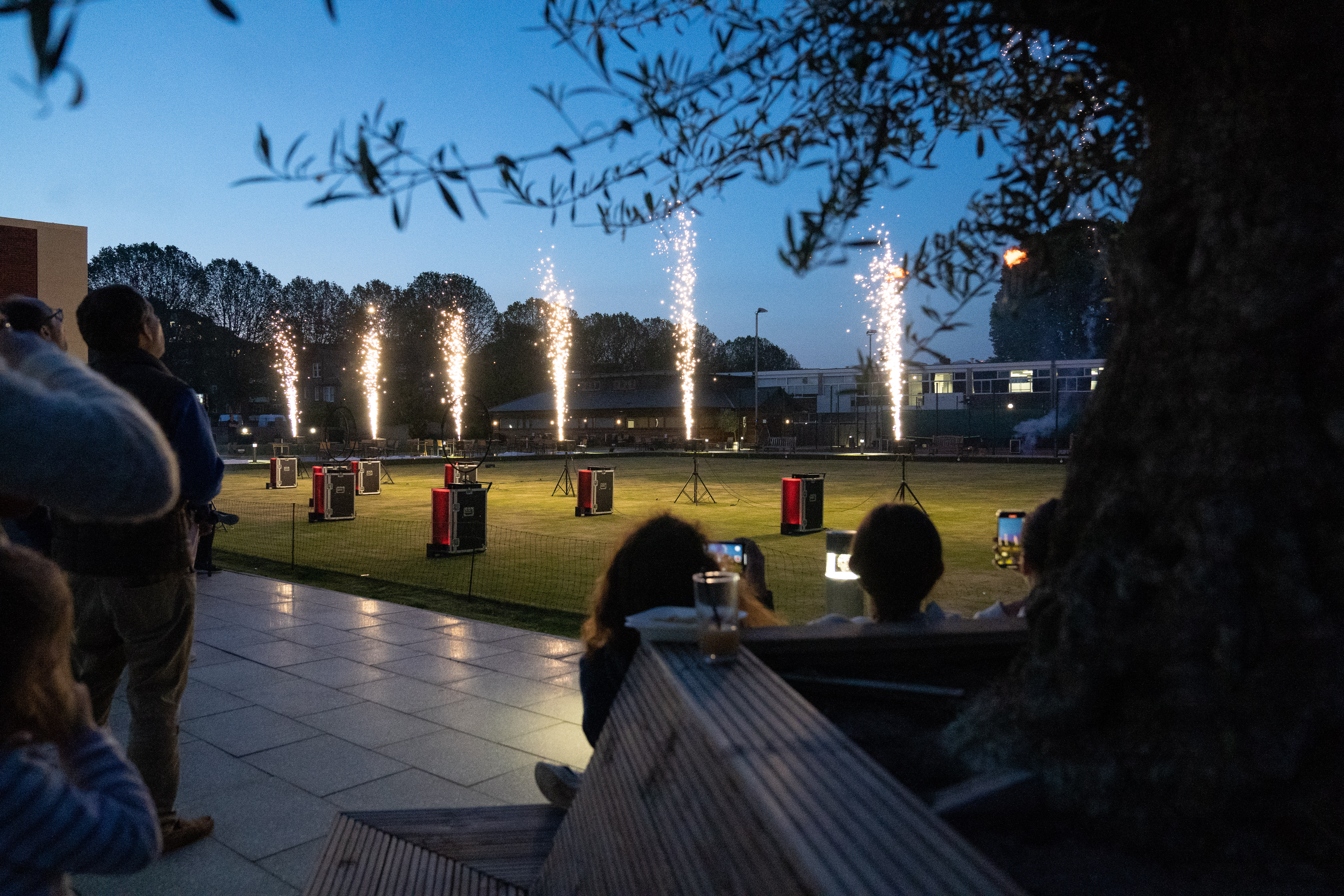 Vibrant outdoor event at Parsons Green Club with fireworks display and seating. - Banner