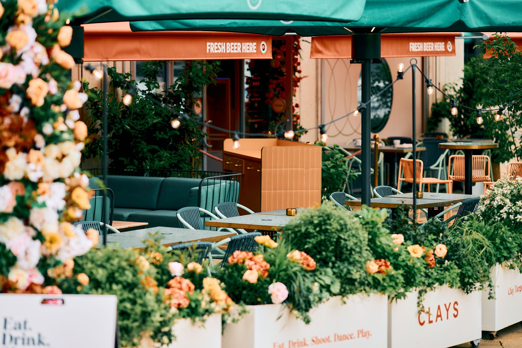 Vibrant outdoor event space at Clays Canary Wharf with lush flowers for summer gatherings. - Banner