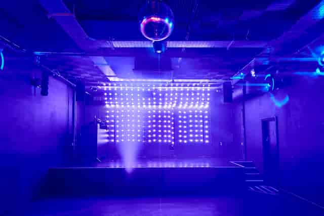 Modern event space at Camden Assembly with vibrant lighting and disco ball for parties.