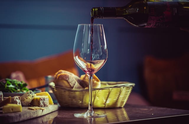 Elegant table setting with red wine, cheese, and bread for networking events.