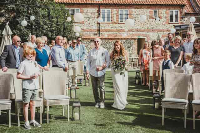 Outdoor wedding ceremony in The Garden Room, featuring a bride and elegant decor.