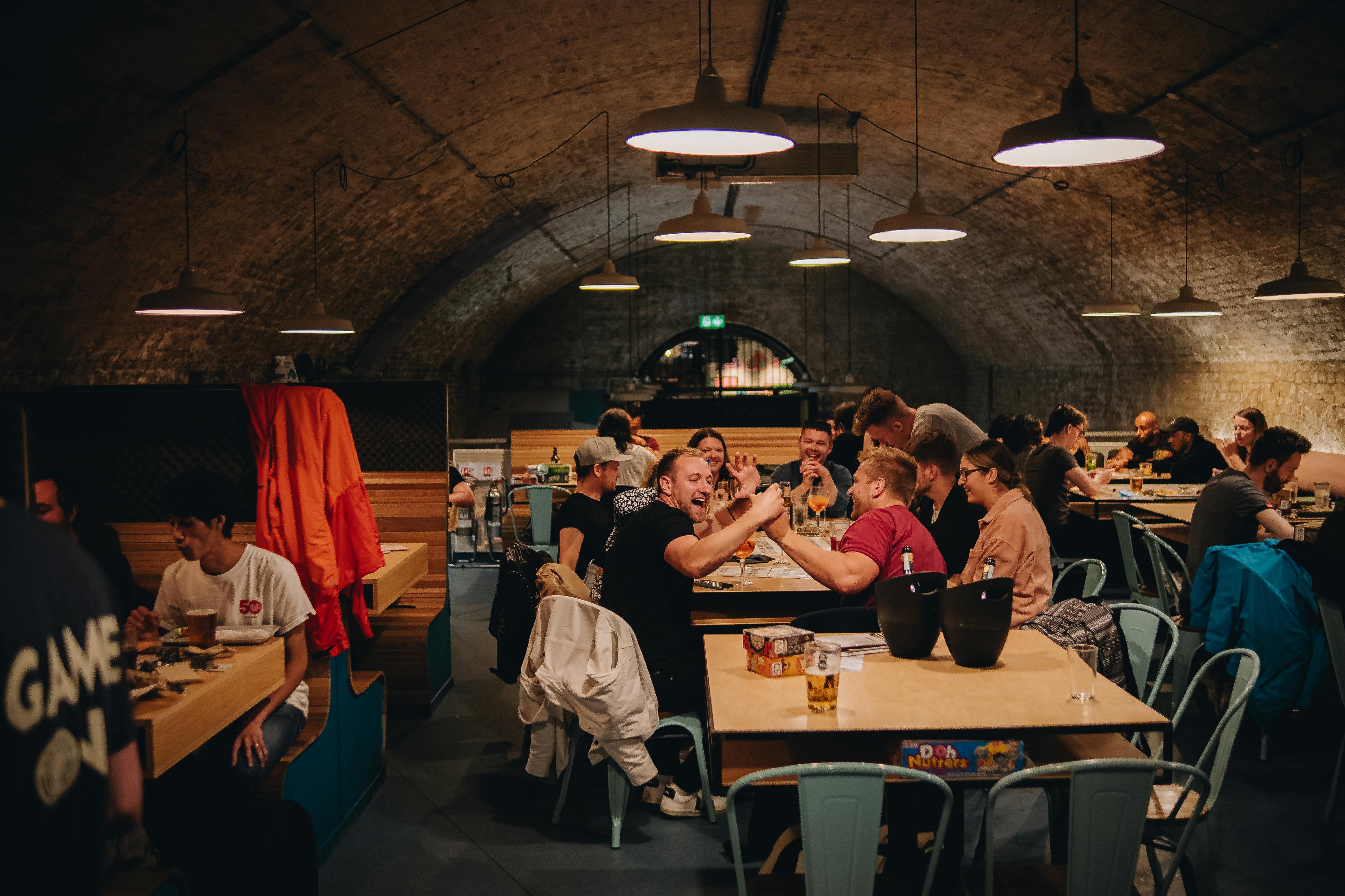 Vibrant Mezzanine event space with rustic archway for networking and team-building activities.