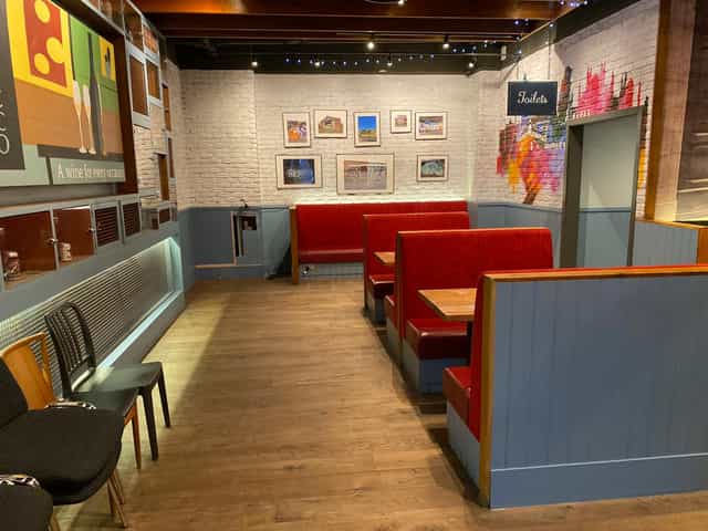 Cozy dining area at LDN Craft with red booths for corporate gatherings and networking events.