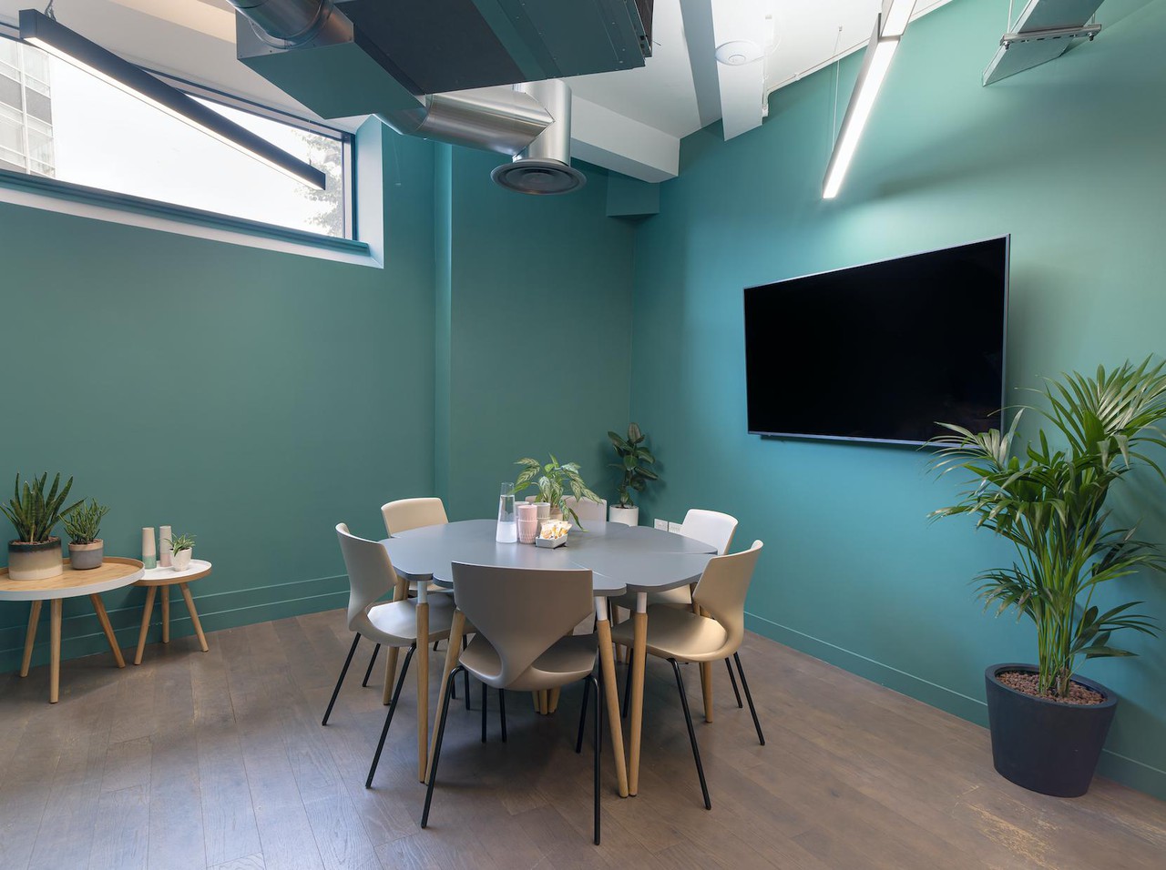 Modern meeting room with teal walls for collaborative team meetings and client presentations.