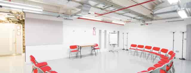 Versatile meeting space with red chairs for workshops at Old Diorama Arts Centre.