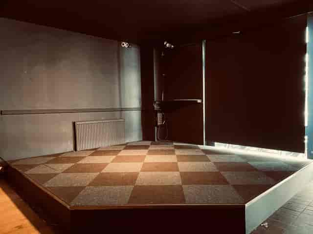 Versatile event space with elevated stage, ideal for presentations and performances.