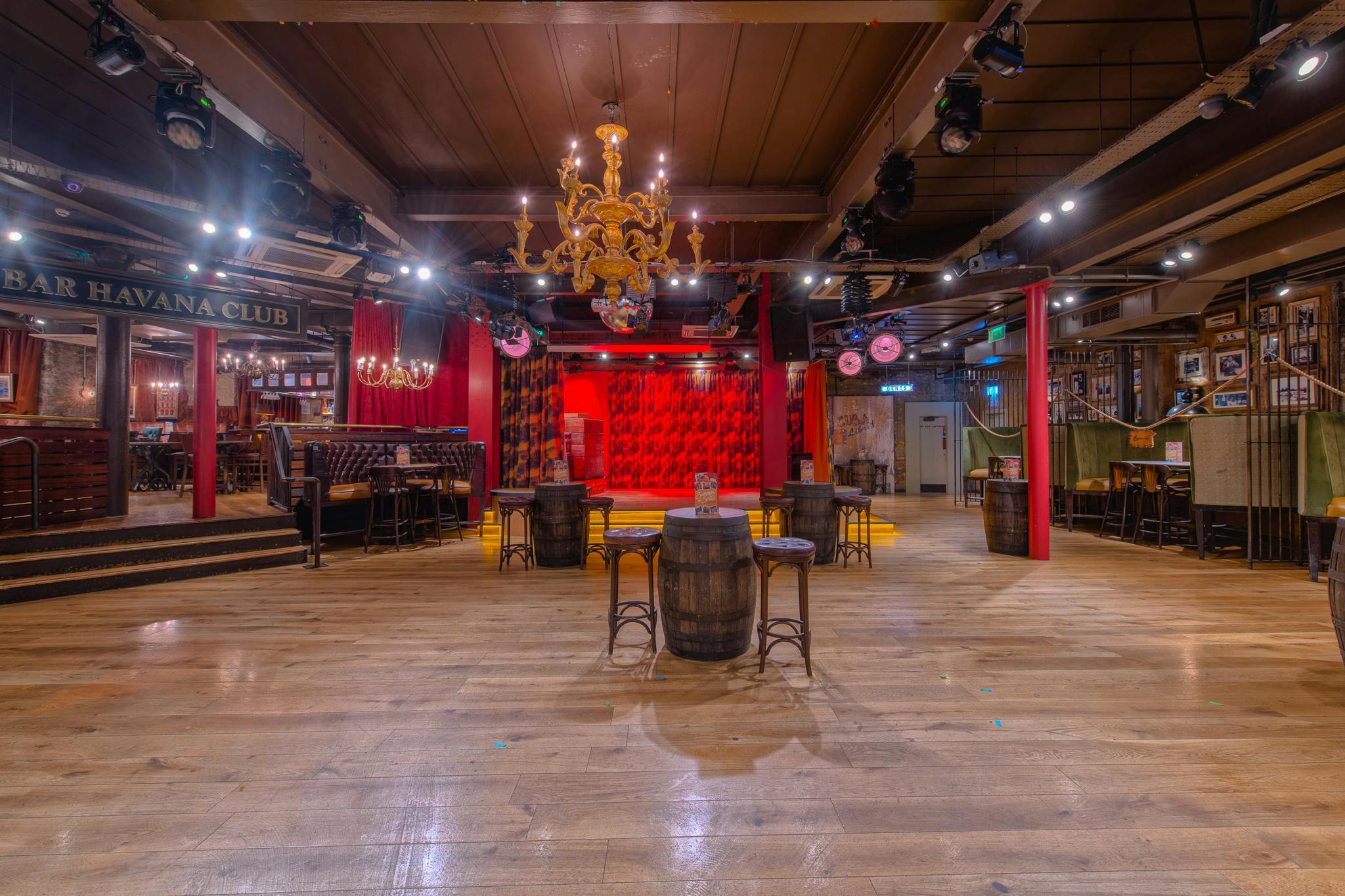 Versatile event space in Revolución de Cuba Manchester with wooden flooring and warm ambiance.