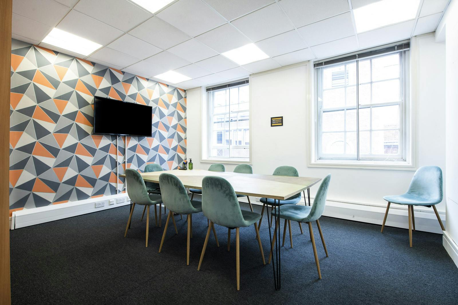 Modern meeting room at Runway East Borough Market with geometric wall and natural light.