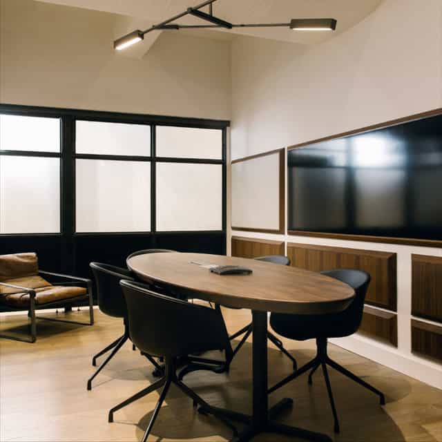 Modern meeting room with oval table, ideal for presentations and brainstorming sessions.