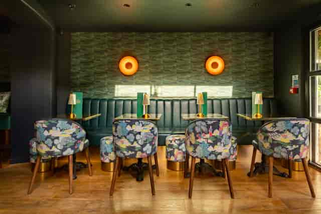 Stylish meeting space at Arthurs Bar with floral chairs, ideal for networking events.