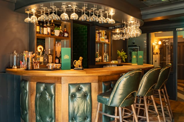 Stylish bar at Aragon House, warm wood accents, ideal for networking events.