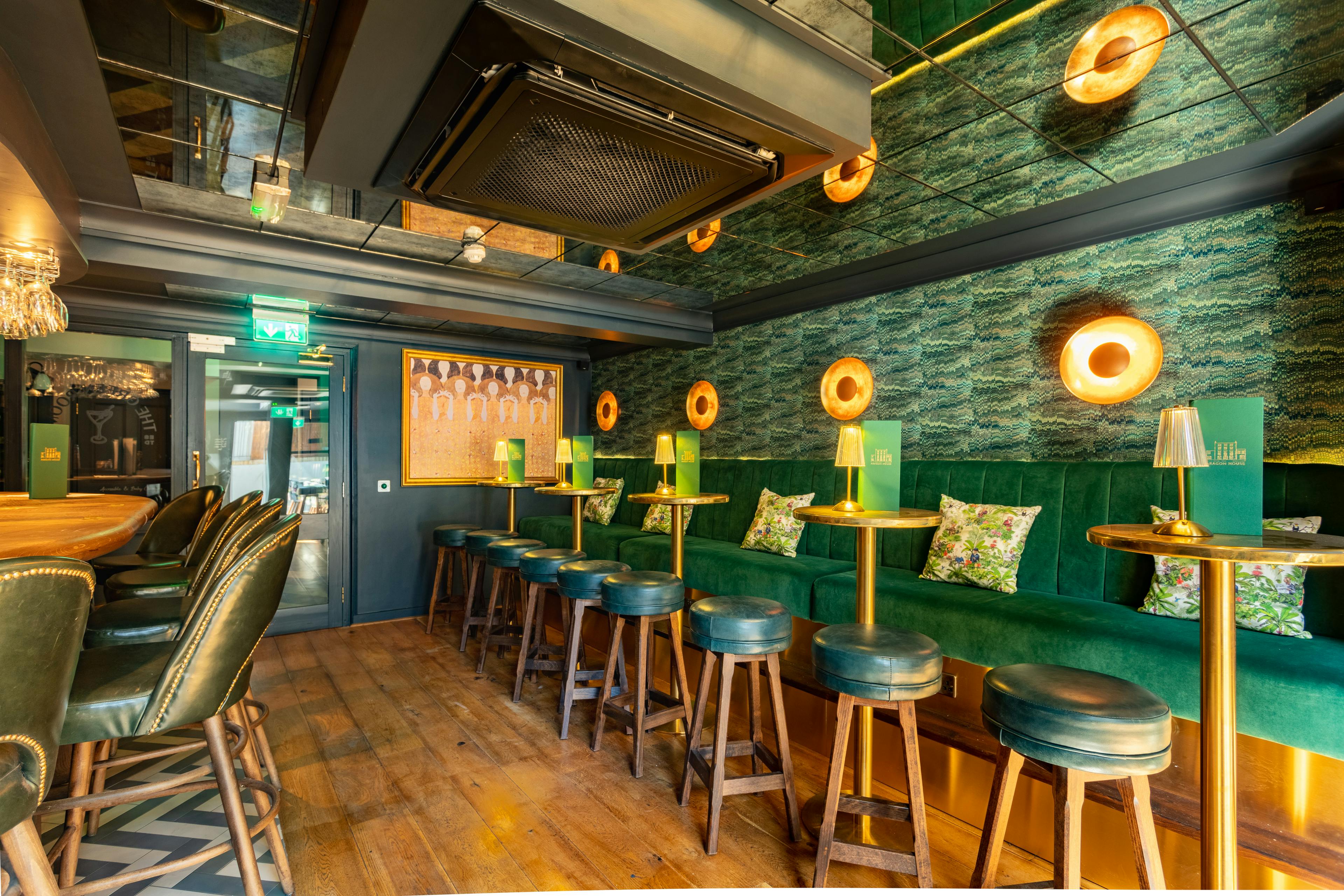 Stylish Arthurs Bar with plush green seating, perfect for networking events and gatherings.