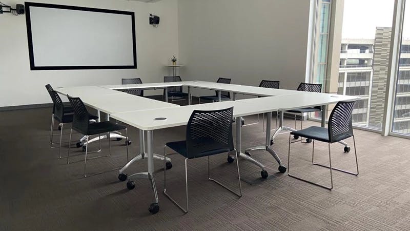 Modern U-shaped meeting room with natural light for collaborative workshops.