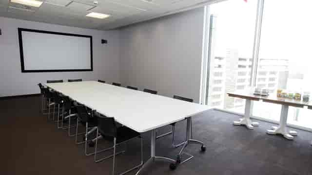 Modern conference room with sleek table and natural light for professional meetings.