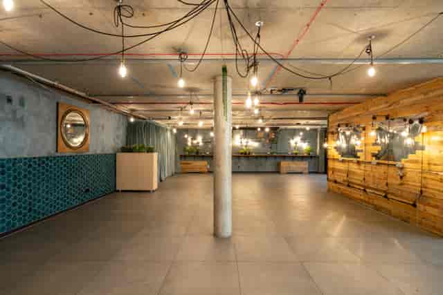 Versatile event space with industrial decor, ideal for corporate meetings and social gatherings.