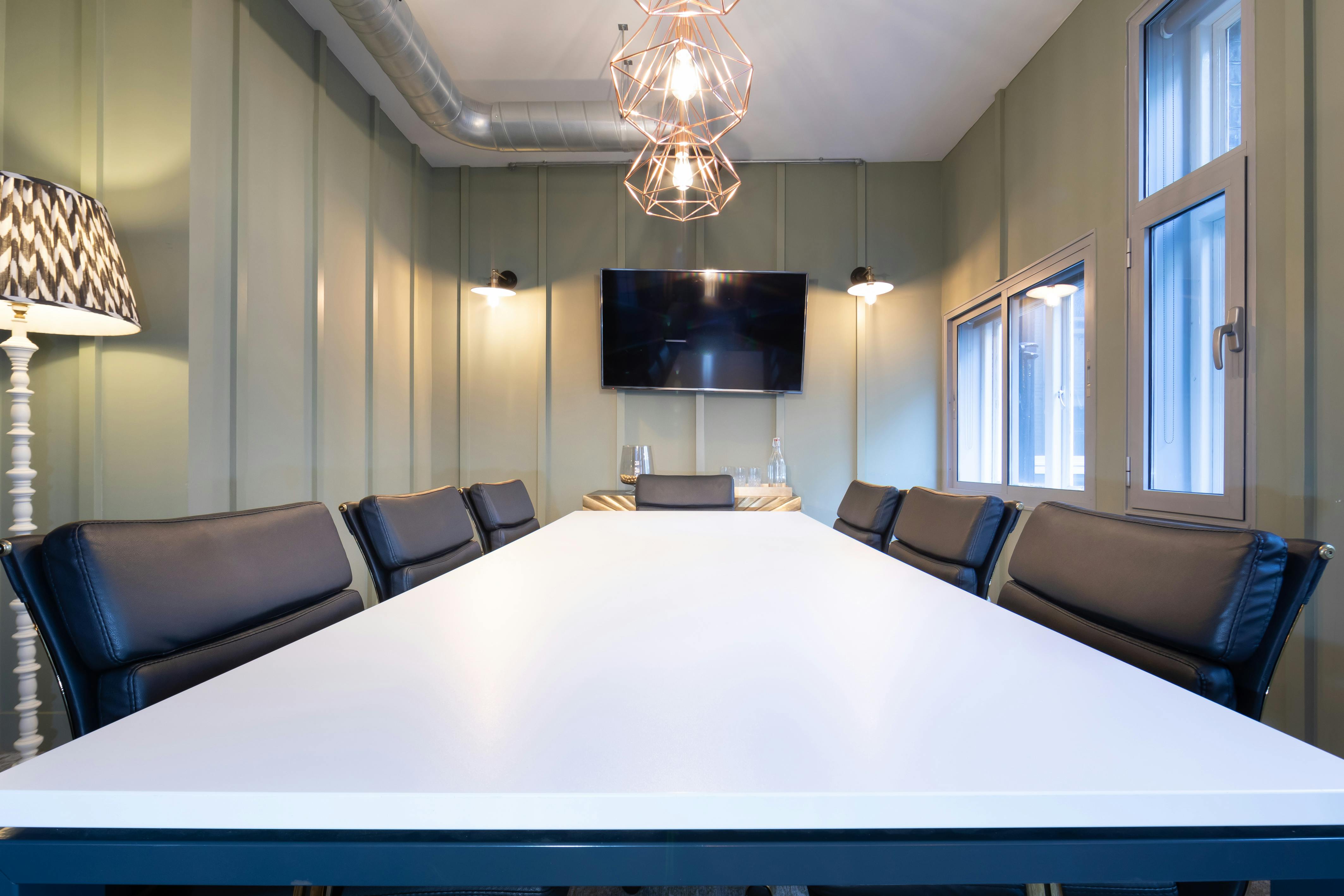 Modern conference room with sleek table and wall-mounted screen for effective meetings.