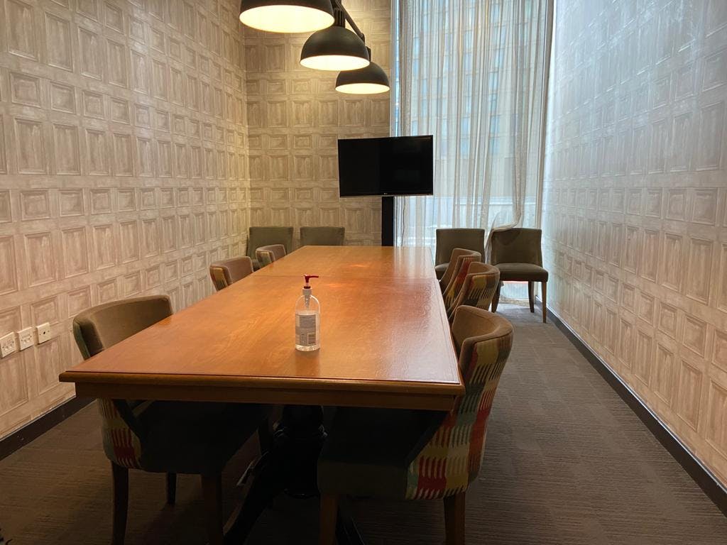 Board room at Host Social with wooden table, ideal for meetings and presentations.