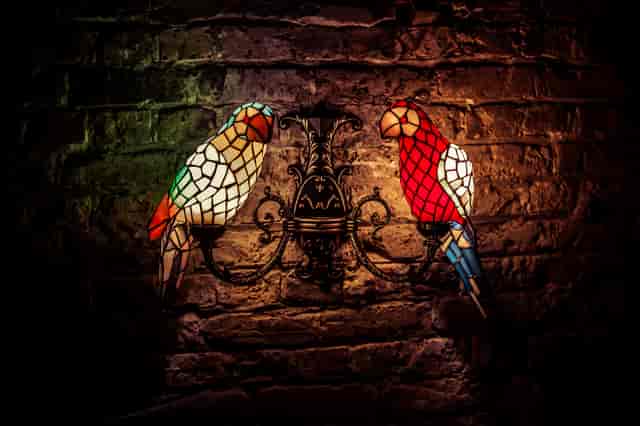 Stained glass parrots at The Cocktail Club Mansion House, perfect for events and gatherings.