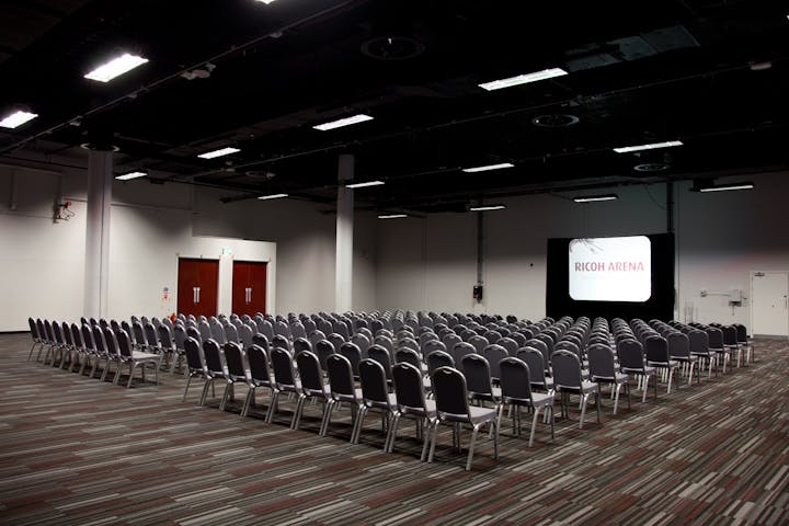 Spacious Coventry Arena event room with chairs for conferences and presentations.