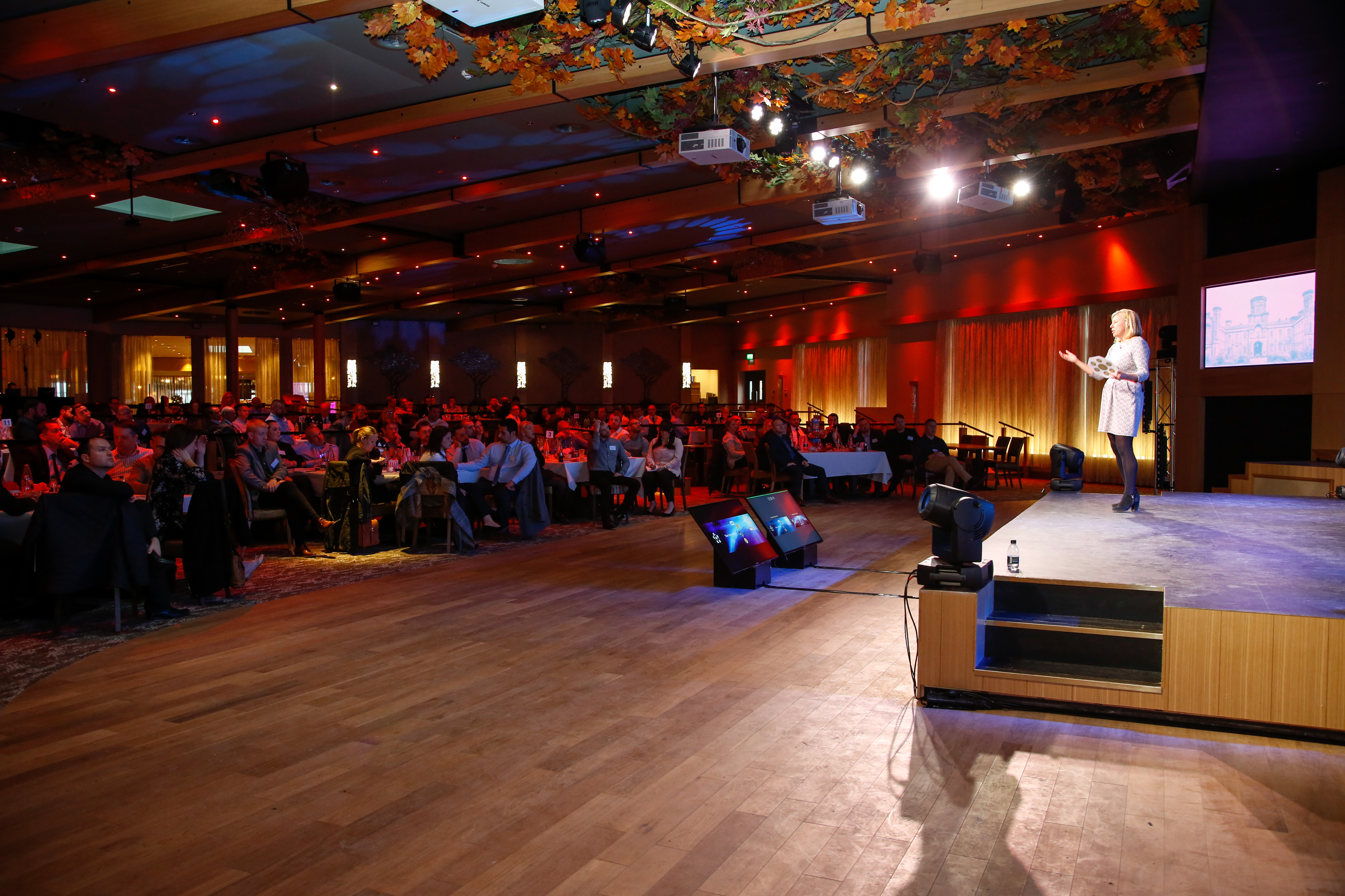 Event at The Evesham, Studley Castle: speaker engaging audience in a vibrant venue. - Banner