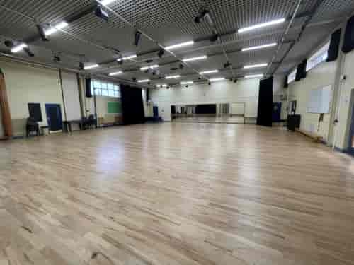 Spacious event space at Copthall School with polished wooden floors for workshops and conferences.