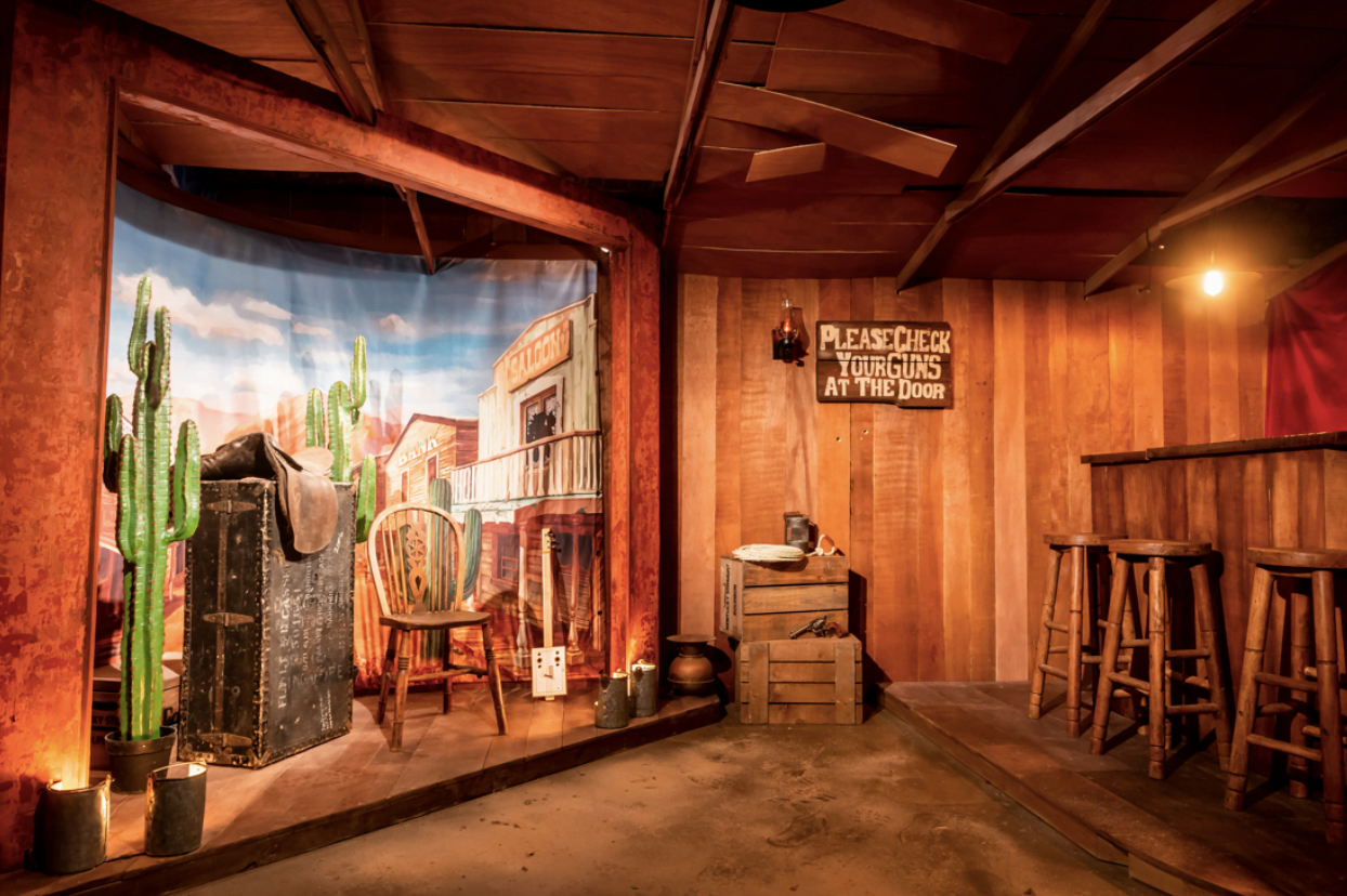 Rustic Western-themed event space with wooden walls, ideal for parties and gatherings. - Banner
