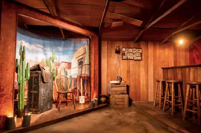 Rustic Western-themed event space with wooden walls, ideal for parties and gatherings.