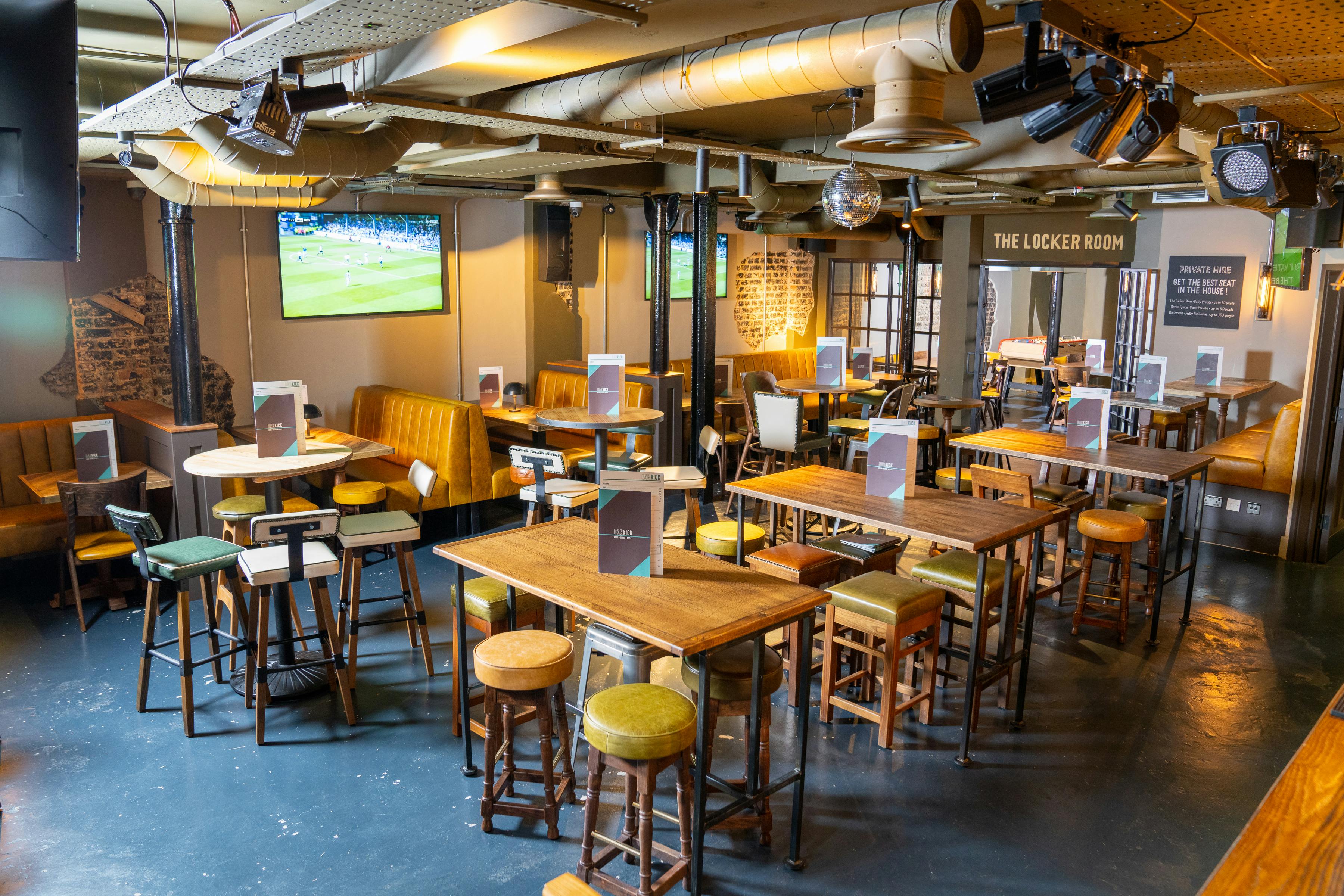 Versatile event space in Bar Kick with warm lighting, perfect for gatherings and sports events.