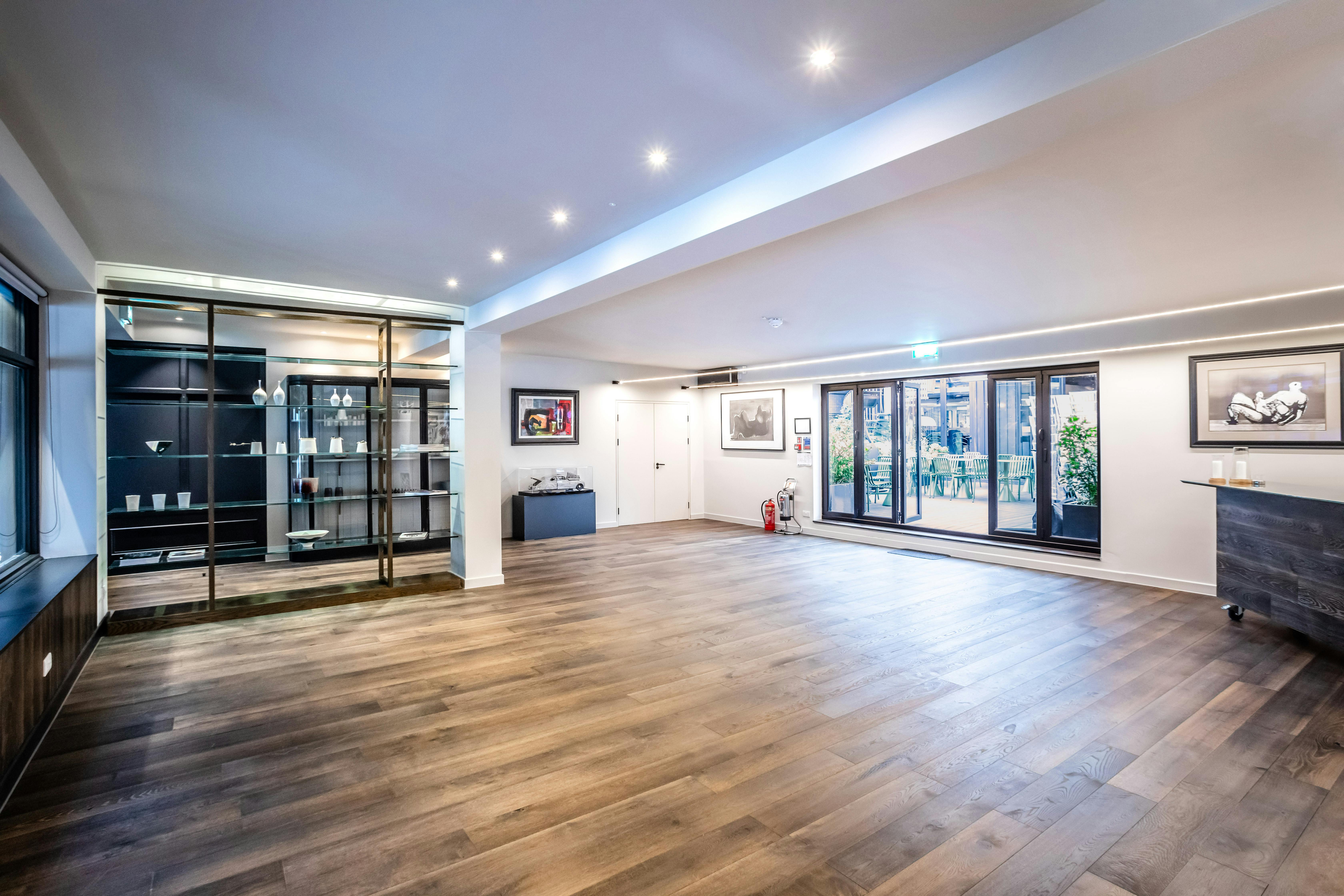 Modern event space with polished wooden floor, ideal for corporate meetings and social gatherings.