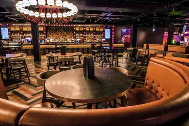 Christmas event at Puttshack Watford with modern seating and vibrant lighting.