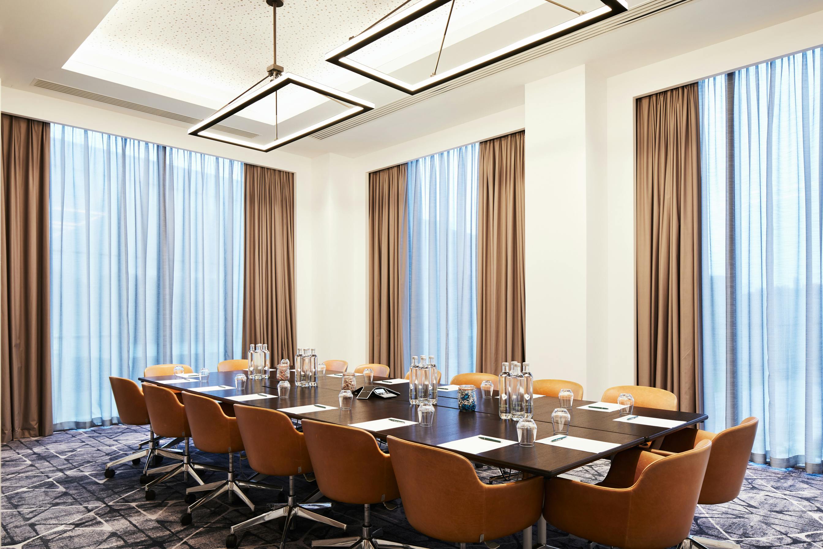 Modern Executive Boardroom at Hyatt Regency Manchester with large table and natural light.