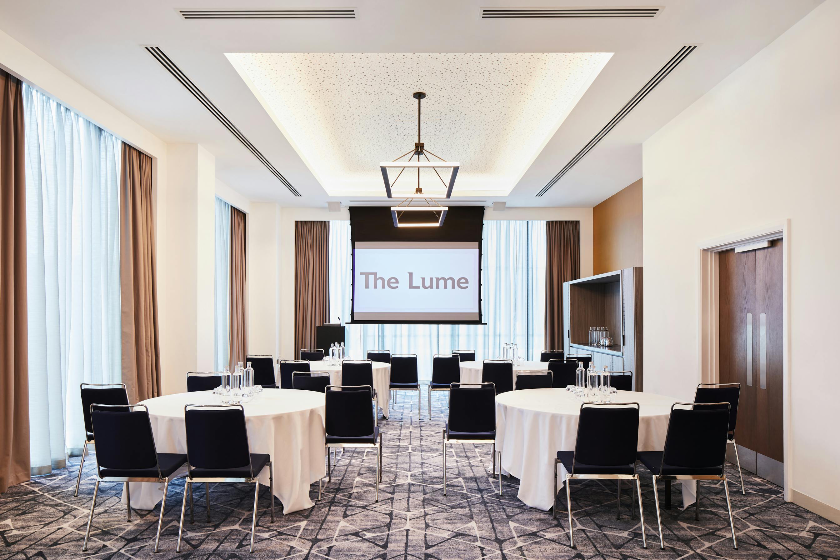 Modern meeting room in Hyatt Regency Manchester with round tables for corporate events.